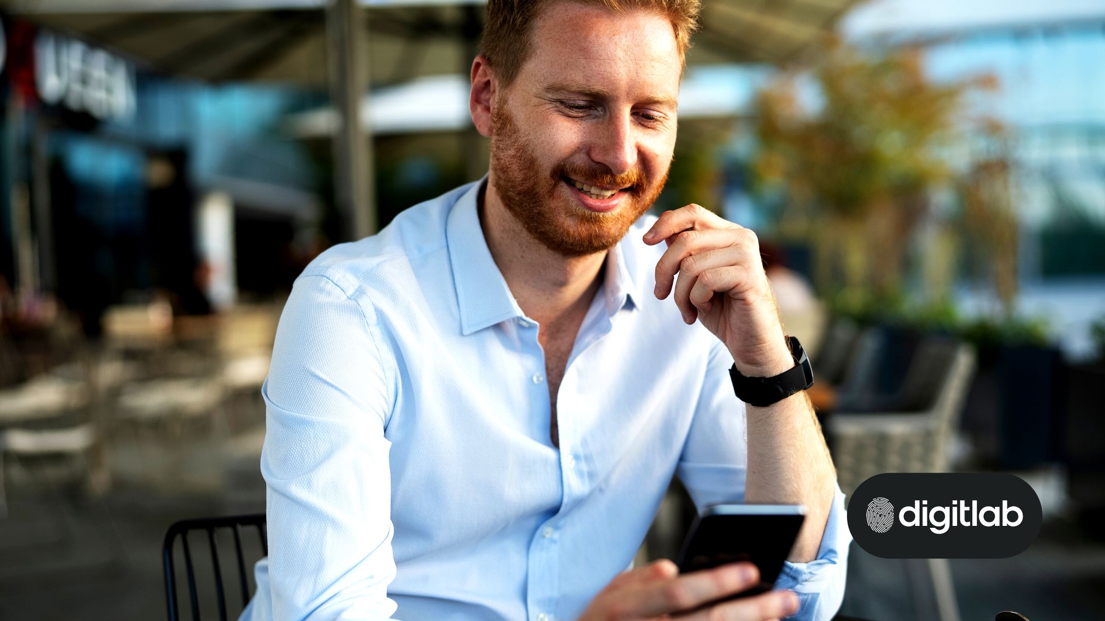 Best digital channels for a fintech marketing strategy - smiling white man looking at his mobile phone.