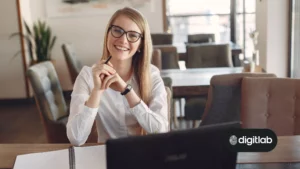 Email Marketing For Startups - woman smiling at camera while working on laptop.