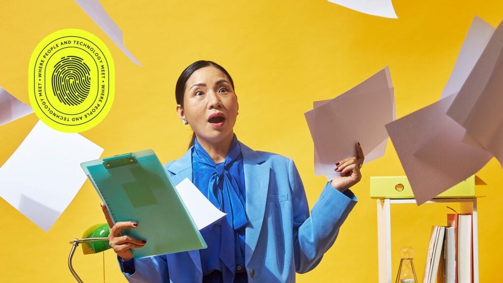 A surprised businesswoman in a bright blue suit holding scattered documents and a clipboard, surrounded by flying papers in a vibrant office setting, symbolizing the complexity and chaos that revenue operations aims to streamline