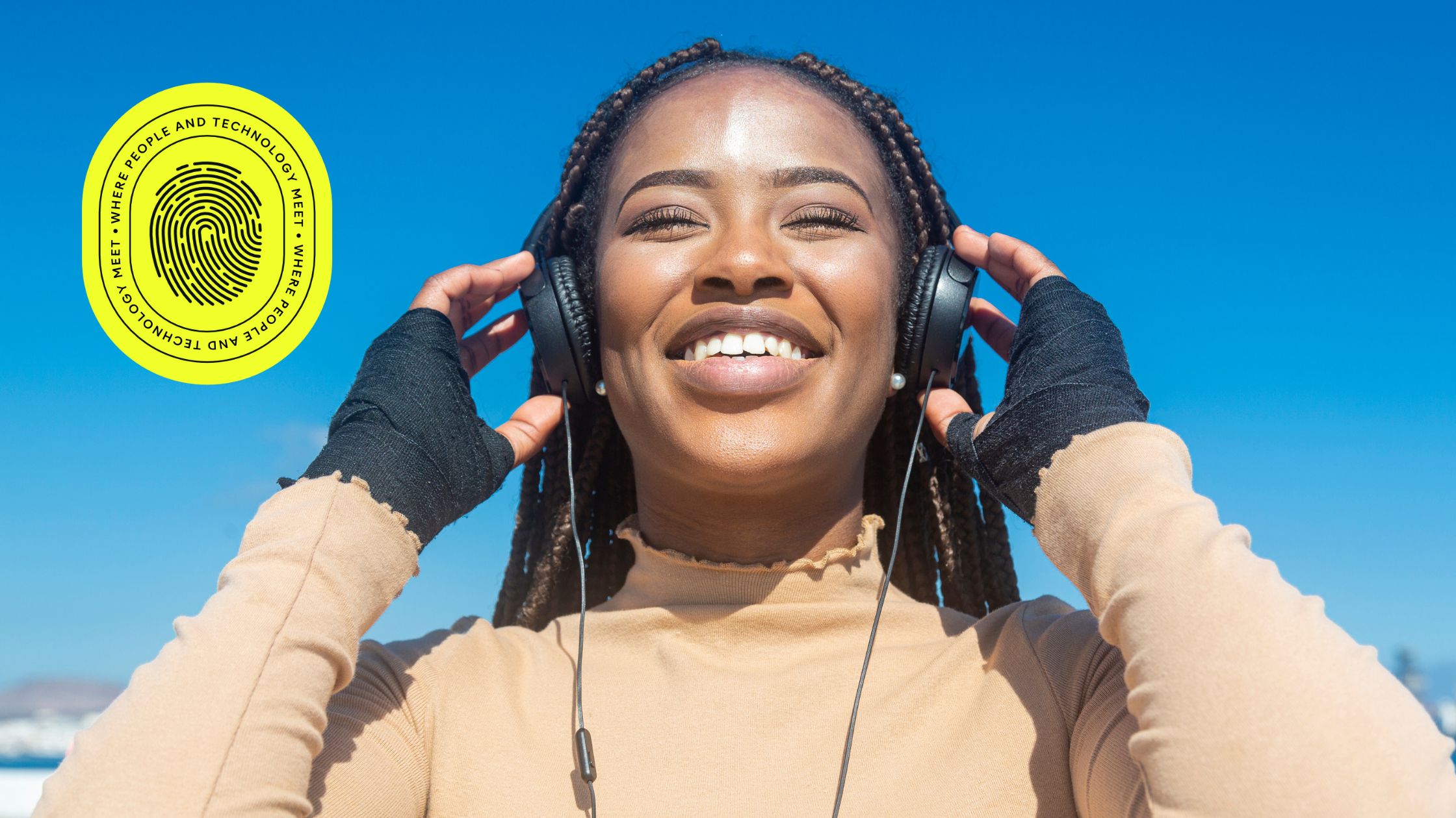 Smiling young woman with braids listening to music on headphones under a clear blue sky, symbolizing clarity and optimism—reflecting the SEO impact of changing domain names for a refreshed digital identity.