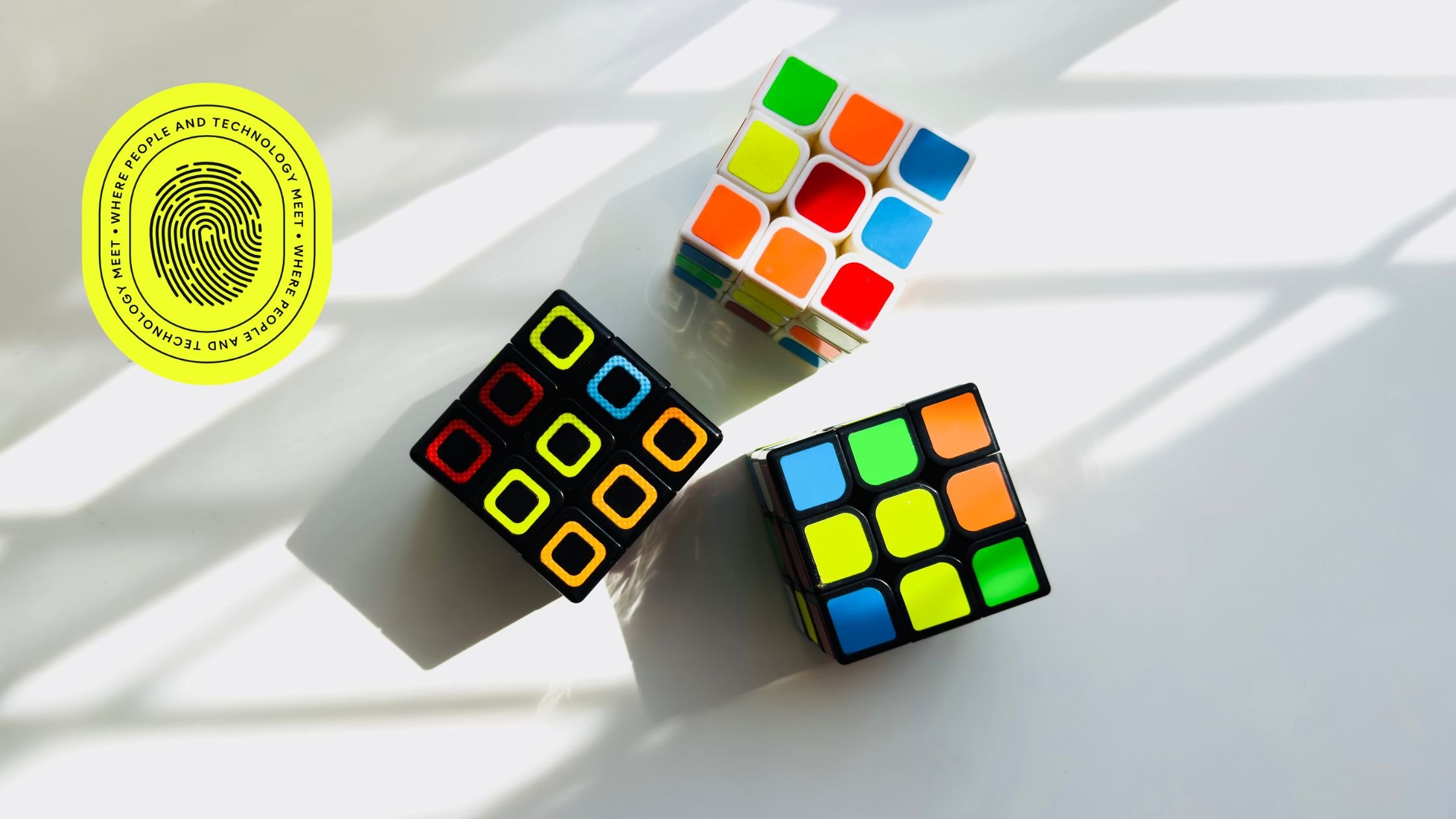 Colourful Rubik’s cubes on a white background with a digital fingerprint logo, symbolising problem-solving and innovation by a lead generation company