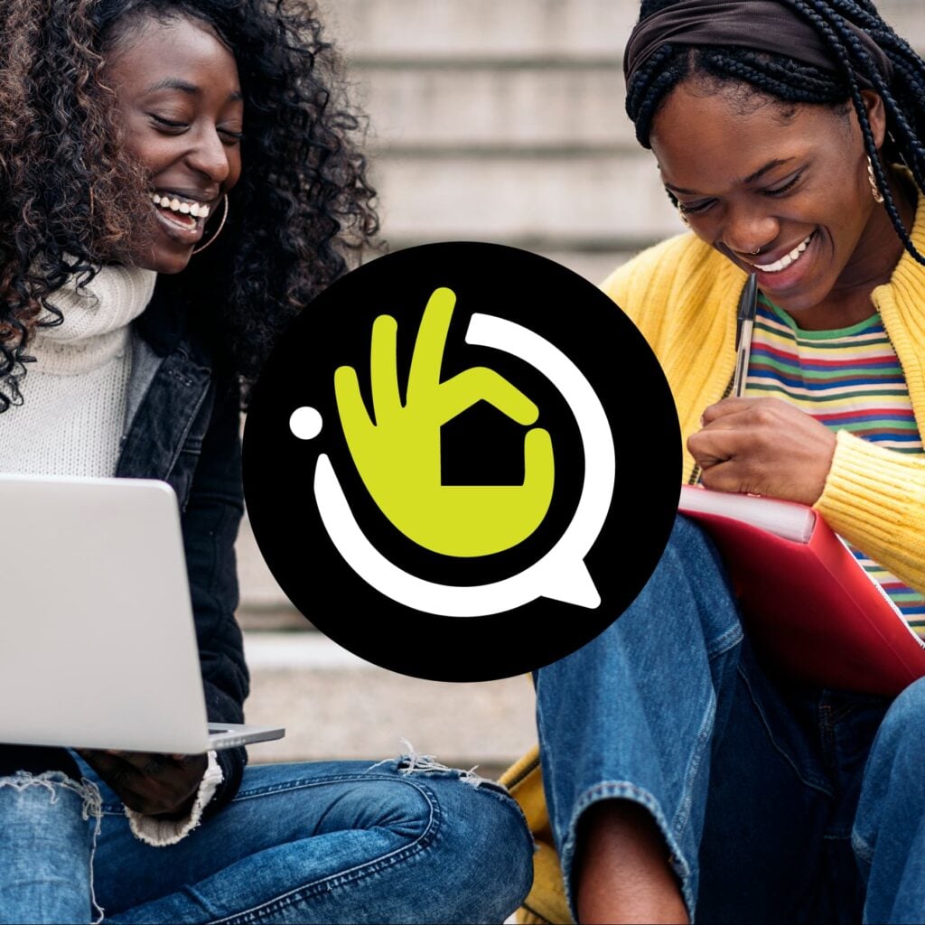 Two women smiling while using laptop and notebook with communication icon overlay